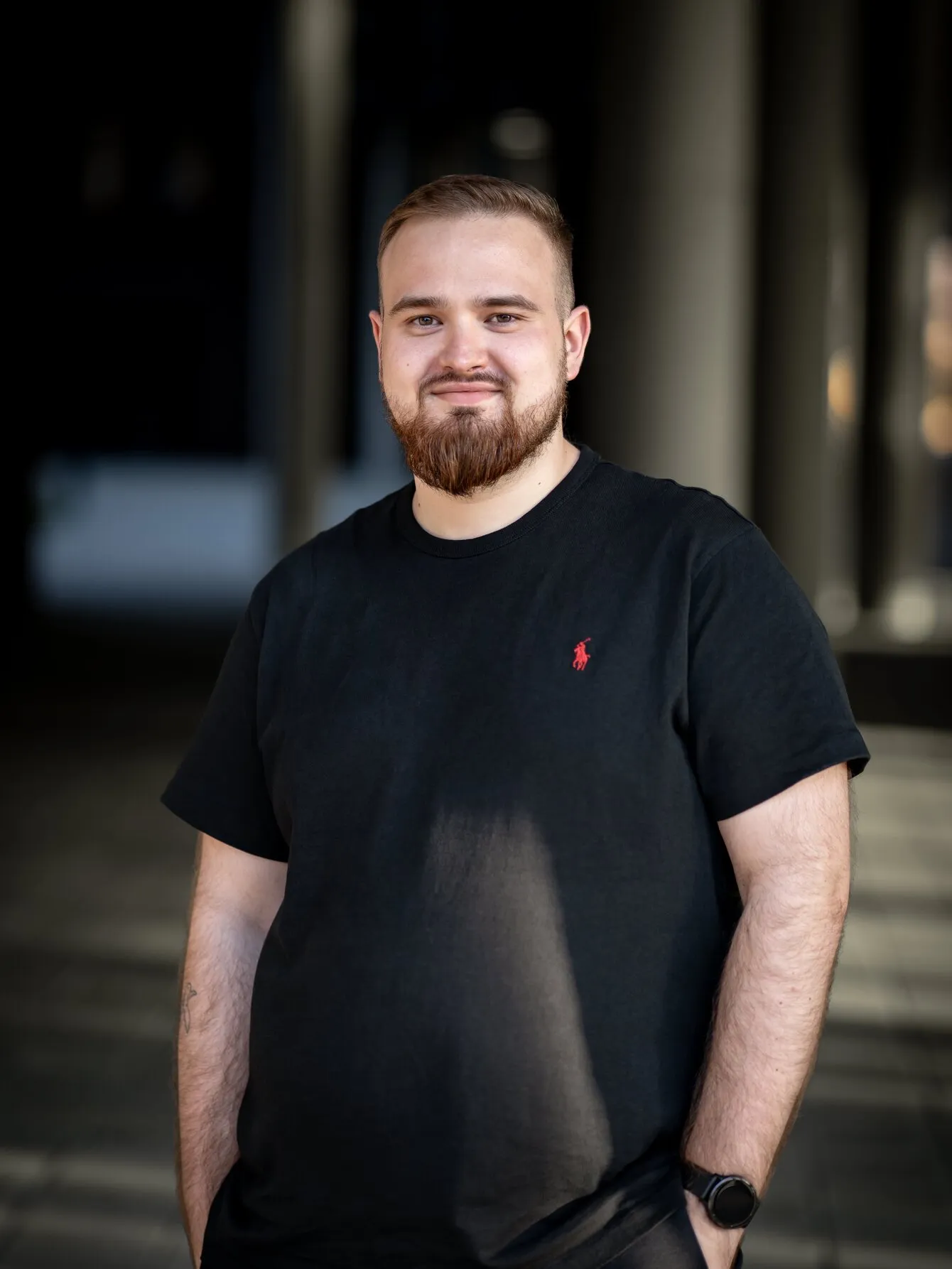 Kamil Kujawa na tle biurowca w Poznaniu